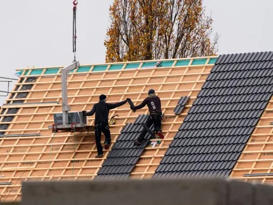 Couvreurs posant des tuiles sur une toiture