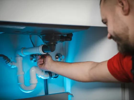 Plombier intervenant sous un évier
